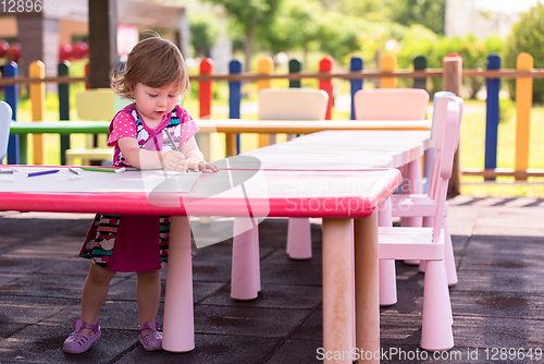 Image of little girl drawing a colorful pictures