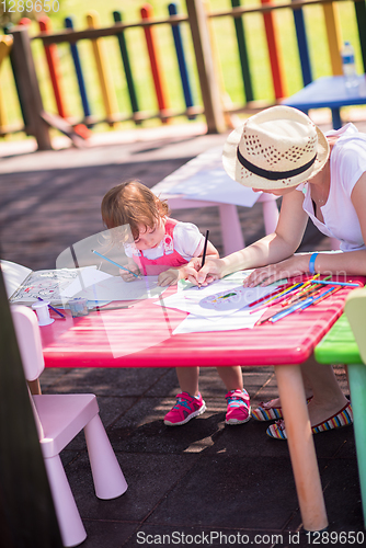 Image of mom and little daughter drawing a colorful pictures