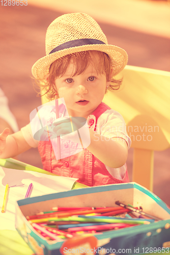 Image of little girl drawing a colorful pictures