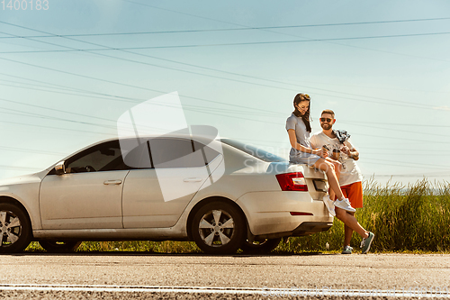 Image of Young couple traveling on the car in sunny day