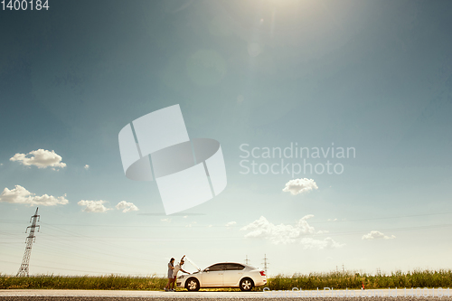 Image of Young couple traveling on the car in sunny day