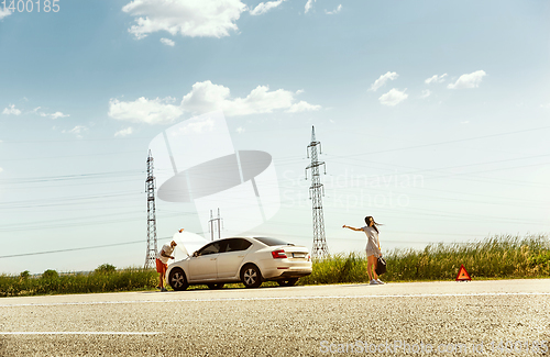 Image of Young couple traveling on the car in sunny day