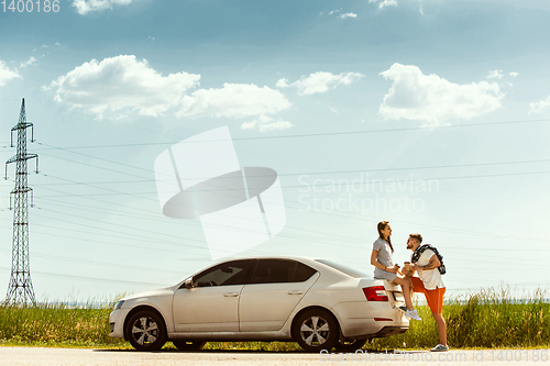 Image of Young couple traveling on the car in sunny day