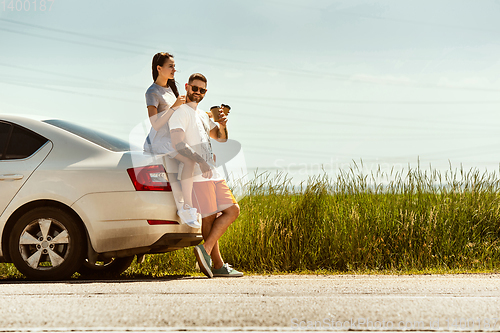 Image of Young couple traveling on the car in sunny day