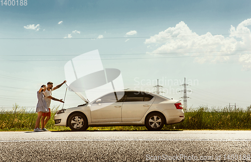 Image of Young couple traveling on the car in sunny day