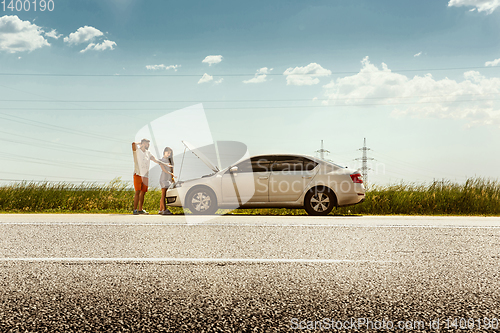 Image of Young couple traveling on the car in sunny day