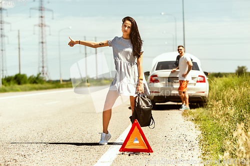 Image of Young couple traveling on the car in sunny day