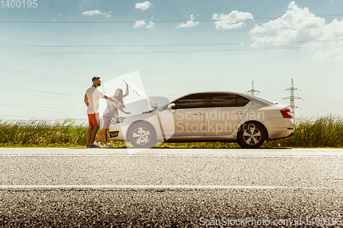 Image of Young couple traveling on the car in sunny day