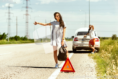 Image of Young couple traveling on the car in sunny day