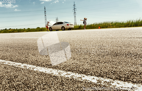 Image of Young couple traveling on the car in sunny day