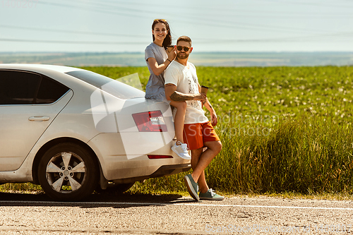 Image of Young couple traveling on the car in sunny day