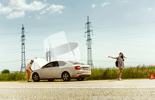 Image of Young couple traveling on the car in sunny day