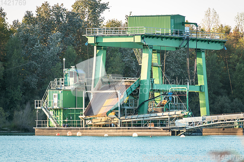 Image of excavator for pebbles on a lake