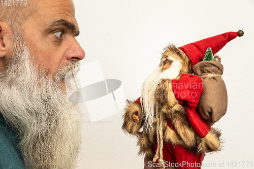 Image of bearded man looking to a Santa Claus puppet