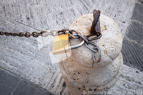 Image of Chain with a lock on a stone pillar