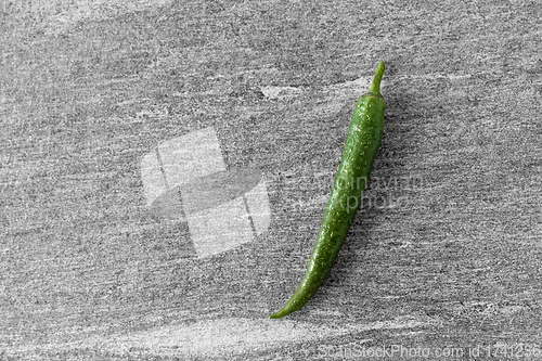 Image of green chili pepper on slate stone background