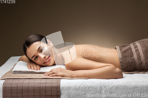 Image of young woman lying at spa or massage parlor