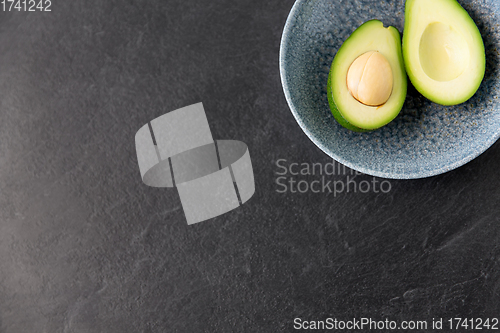 Image of close up of ripe avocado with bone in ceramic bowl