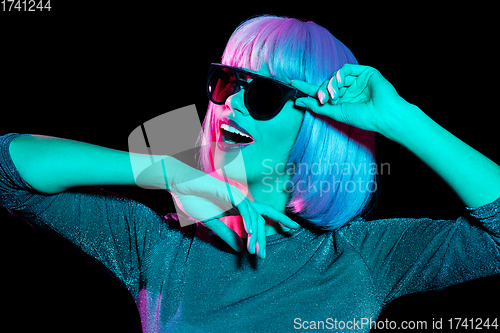 Image of happy woman in pink wig and sunglasses dancing