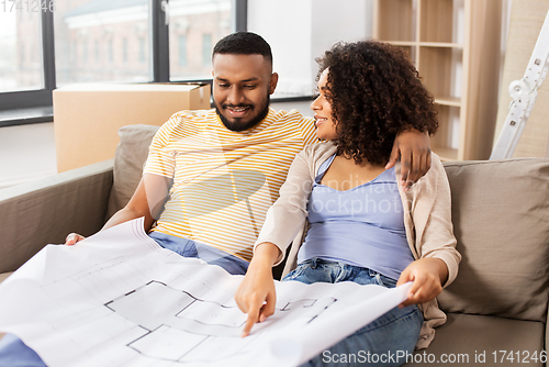 Image of couple with boxes and blueprint moving to new home