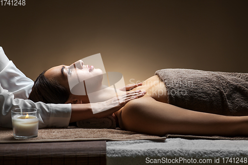 Image of woman having face and head massage at spa