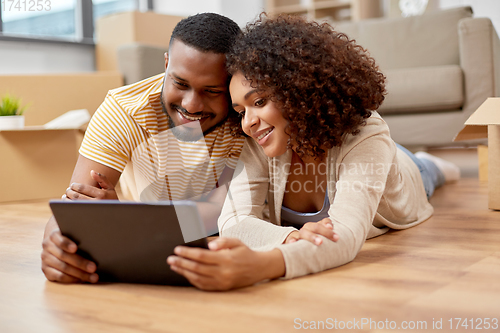 Image of happy couple with tablet pc computer at new home