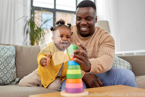 Image of african family playing with baby daughter at home