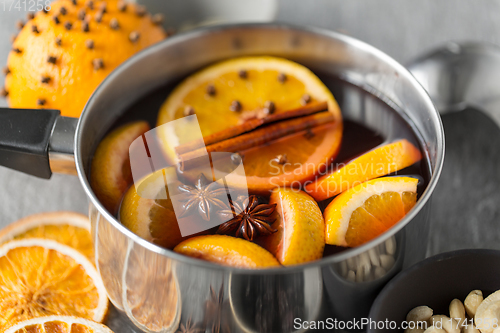 Image of pot with hot mulled wine, orange slices and spices