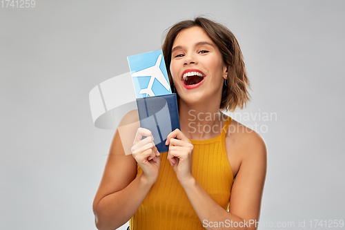 Image of happy young woman with air ticket and passport