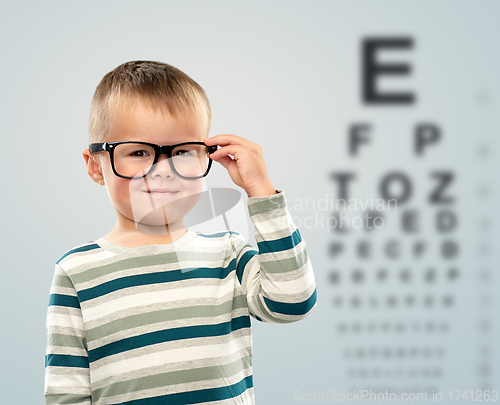 Image of little boy in glasses over eye test chart