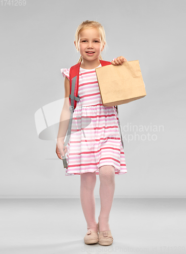 Image of little student girl with school lunch in paper bag