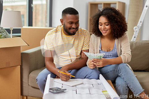 Image of couple with blueprint counting money at home