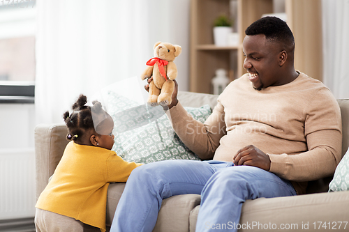 Image of african american father playing with baby at home