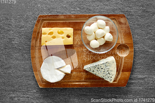 Image of different kinds of cheese on wooden cutting board