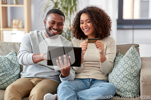 Image of couple with tablet pc and credit card at home