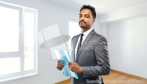 Image of indian man realtor with folder at new apartment