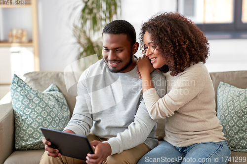 Image of african american couple with tablet pc at home