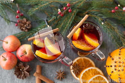 Image of glass of hot mulled wine, cookies, apples and fir