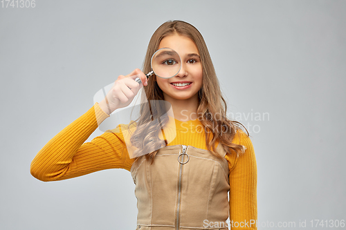 Image of teenage girl looking through magnifying glass