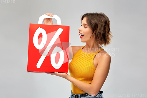 Image of happy young woman with shopping bag on sale
