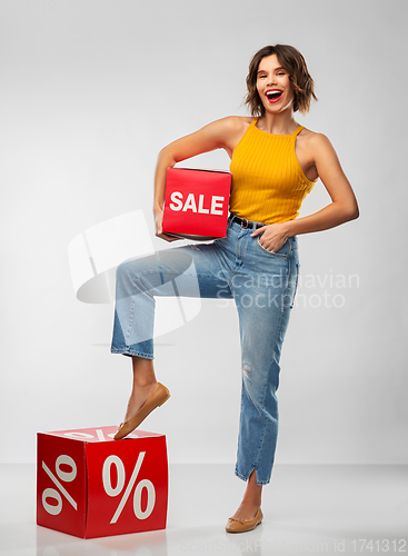 Image of happy smiling young woman with sale signs