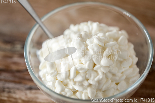 Image of close up of cottage cheese in bowl on wooden table