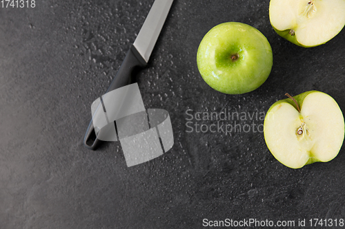 Image of green apples and kitchen knife on slate background