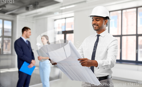 Image of indian male architect in helmet with blueprint