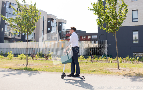 Image of businessman with shopping bag riding scooter