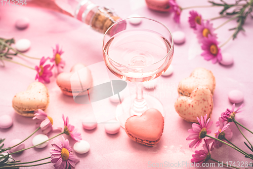 Image of Happy Mothers Day - sweet macarons in heart shape and glass of rose sparkling wine