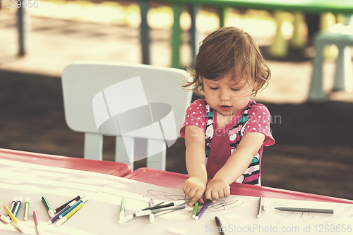 Image of little girl drawing a colorful pictures