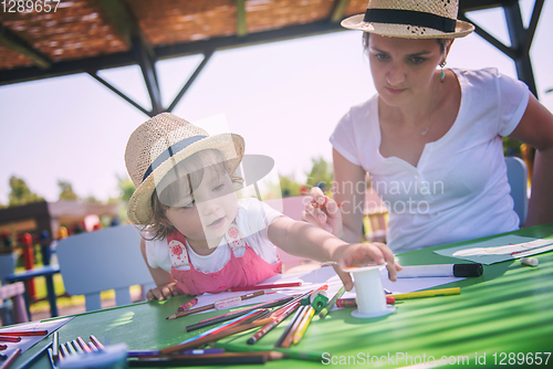 Image of mom and little daughter drawing a colorful pictures