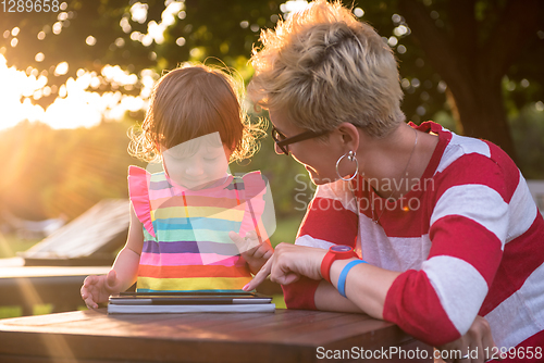 Image of mom and her little daughter using tablet computer