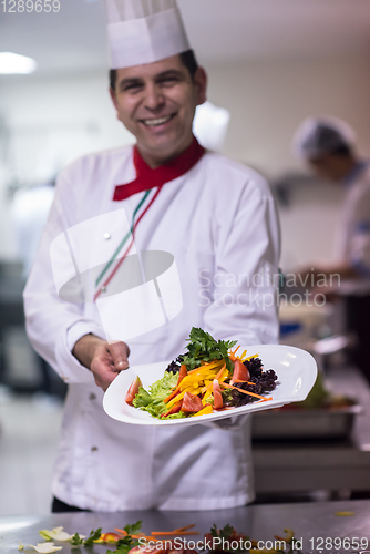 Image of Chef showing a plate of tasty meal